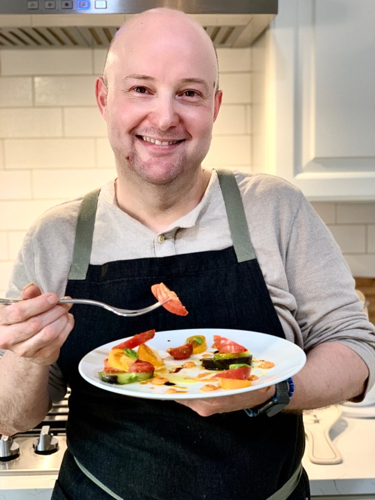 Chef Rafael Gonzalez in his home kitchen with a caprese salad